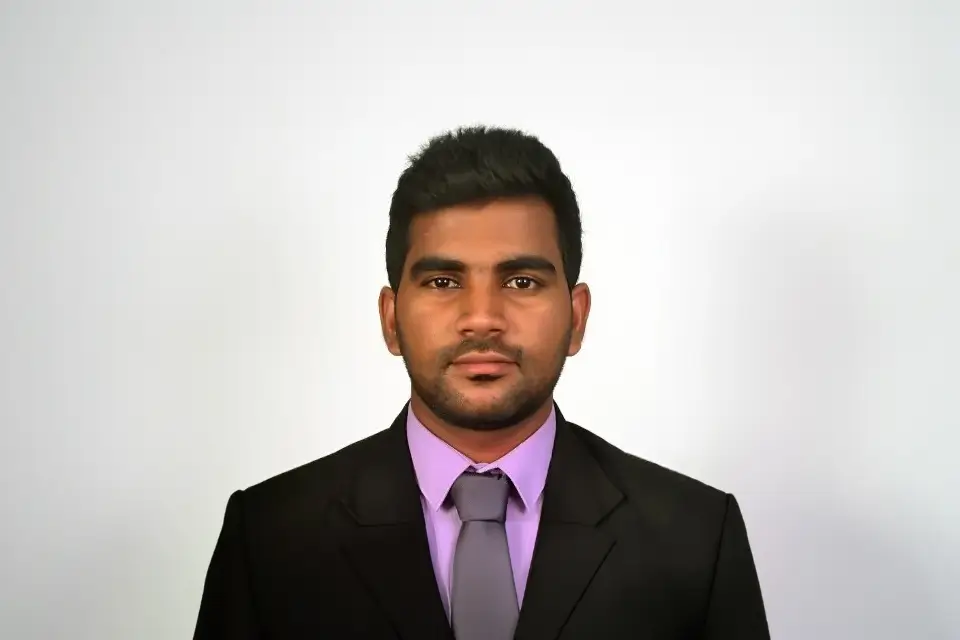 A male H connect employee wearing a black blazer in a white background