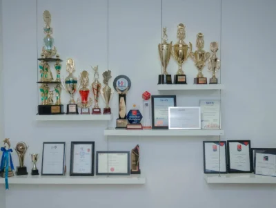 A wall display with numerous trophies and awards.
