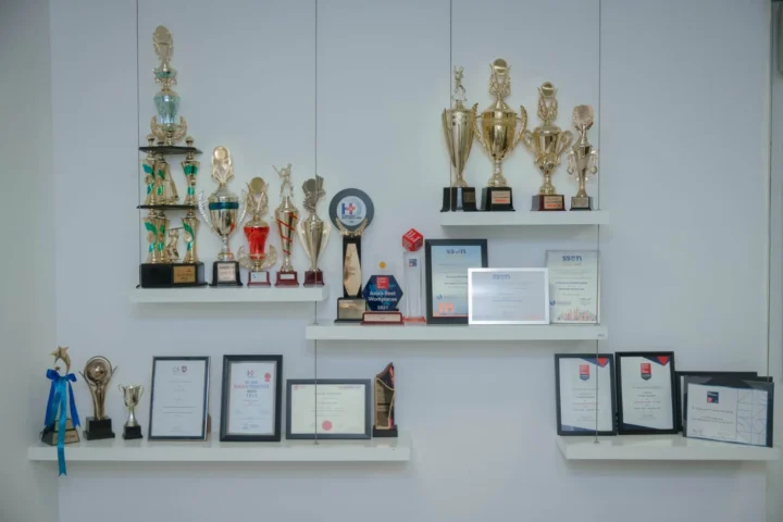A wall display with numerous trophies and awards.