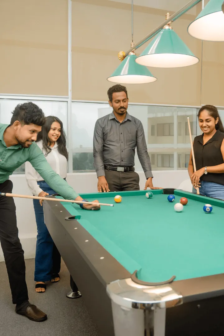 H Connect coworkers enjoying a casual game of pool together in a relaxed office space