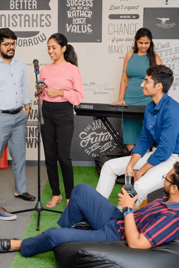 H Connect empoyees having a chat in a open space with a keyboard and few muscial instruments