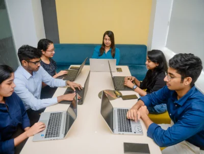 Six young professionals working on laptops.