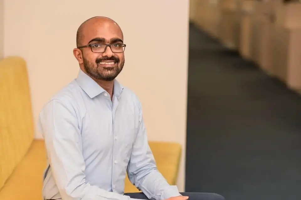A male h connect employee with white shirt office attair with spectacles