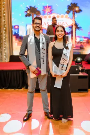 A man and woman smiling with sashes.