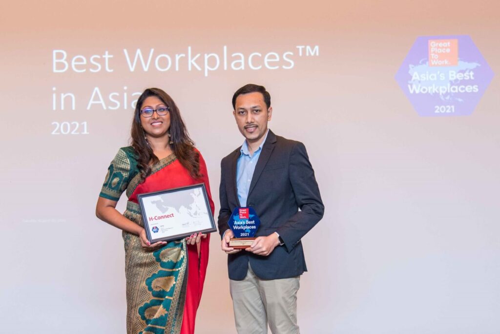 A man and a woman are holding an award.