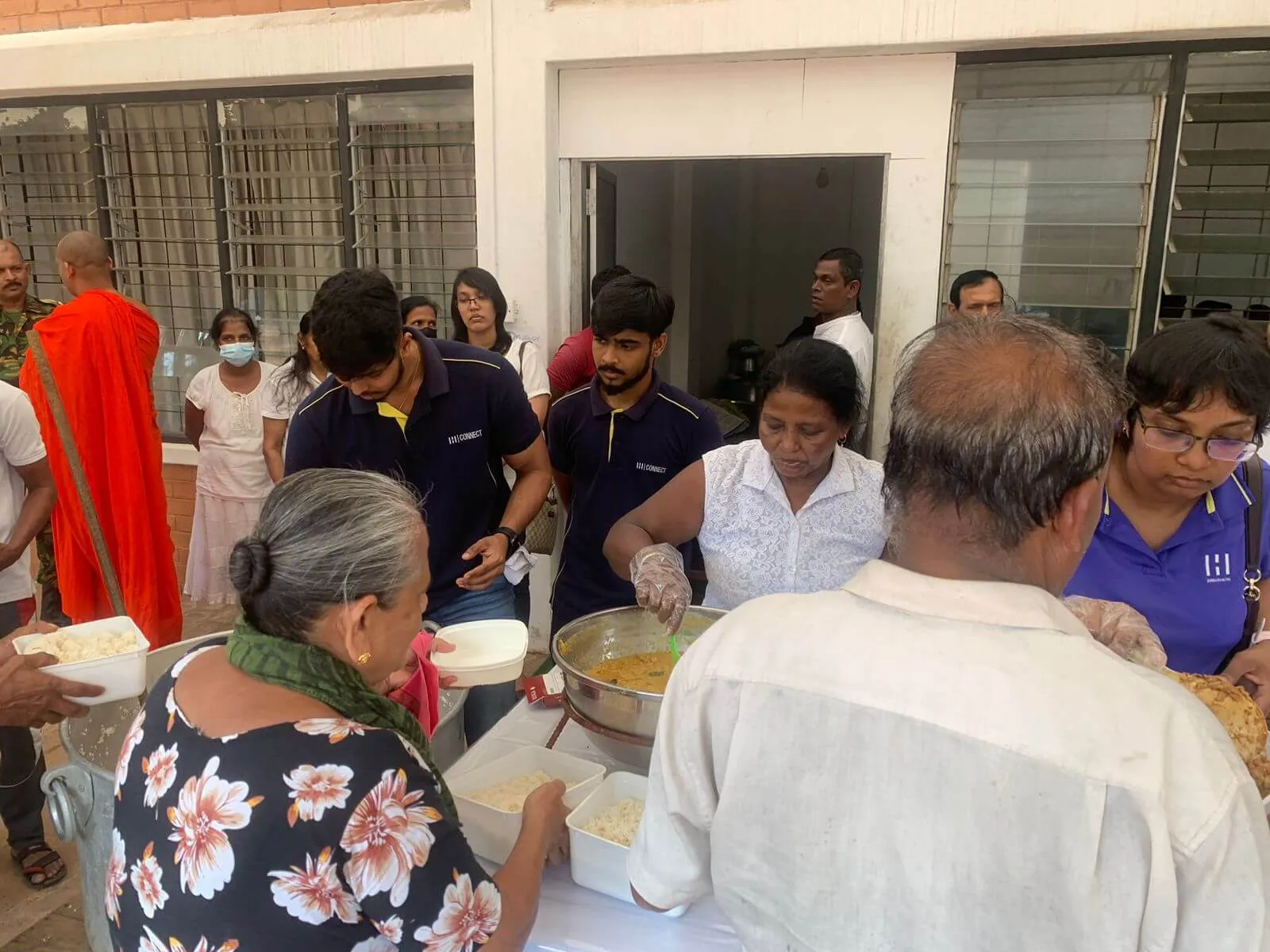 A line of people being served food.